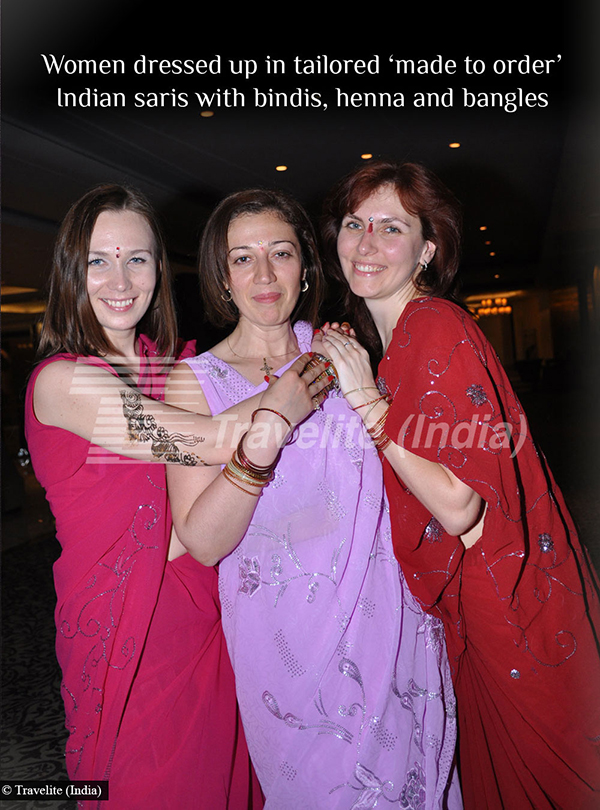 Women dressed up in tailored 'made to order', Indian saris with bindis, henna and bangles